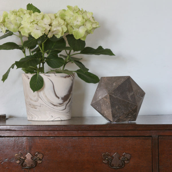 Black marble polyhedron objet on table