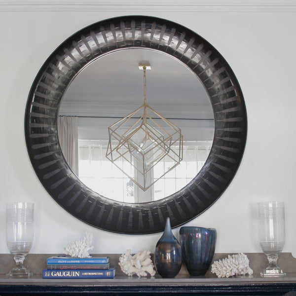 Patterned inlaid round mirror in black above mantle